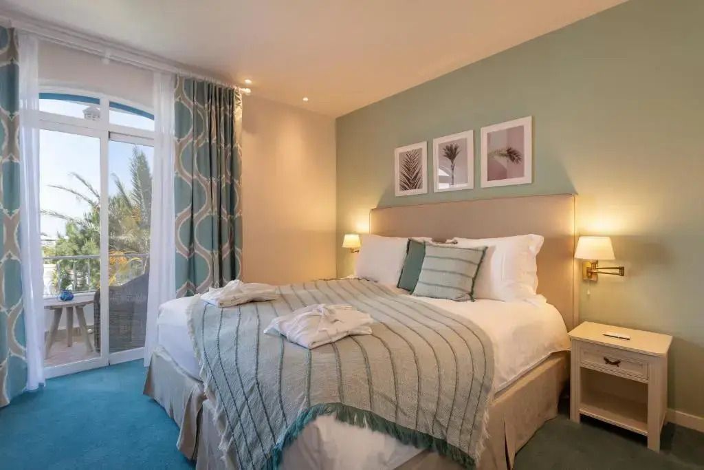Gemütliches Schlafzimmer mit großem Bett und Blick nach draußen.