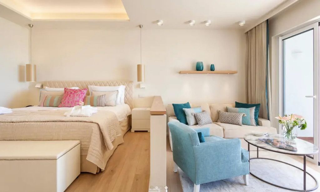 Helles Deluxe Doppelzimmer mit gemütlichem Sitzbereich und stilvoller Dekoration