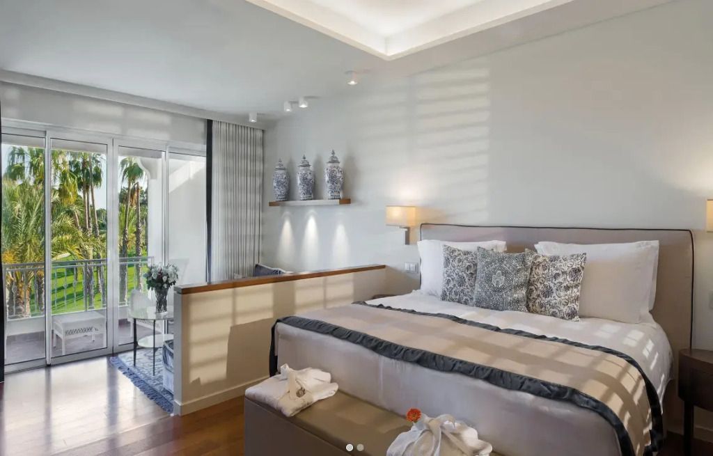 Geräumiges Schlafzimmer mit großen Fenstern und gemütlicher Sitzecke