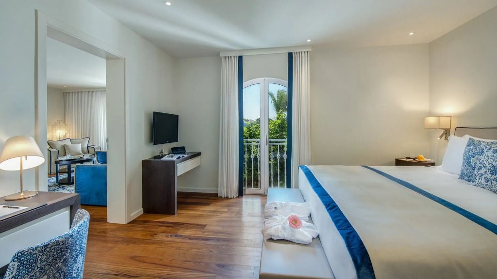 Helles Schlafzimmer mit großem Bett und Blick auf den Garten im Vila Vita Parc.