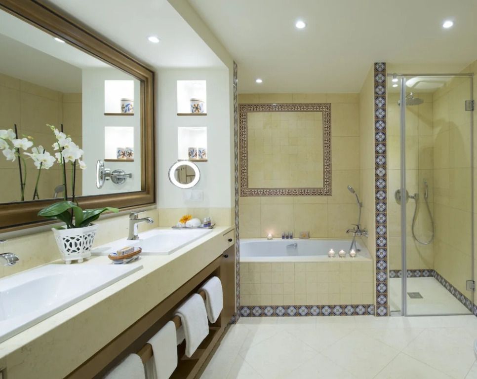 Luxusbad im Vila Vita Parc mit Doppelwaschbecken und Badewanne in eleganter Umgebung.