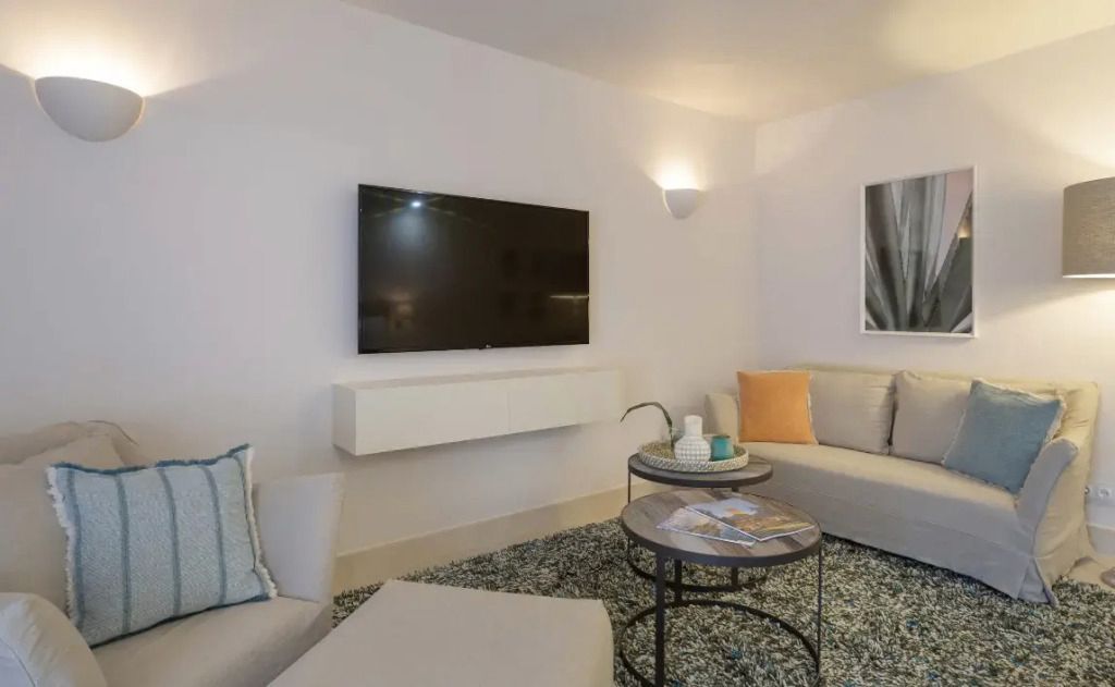 Wohnbereich mit bequemen Sofas flachem Fernseher und Couchtischen mit Dekoration