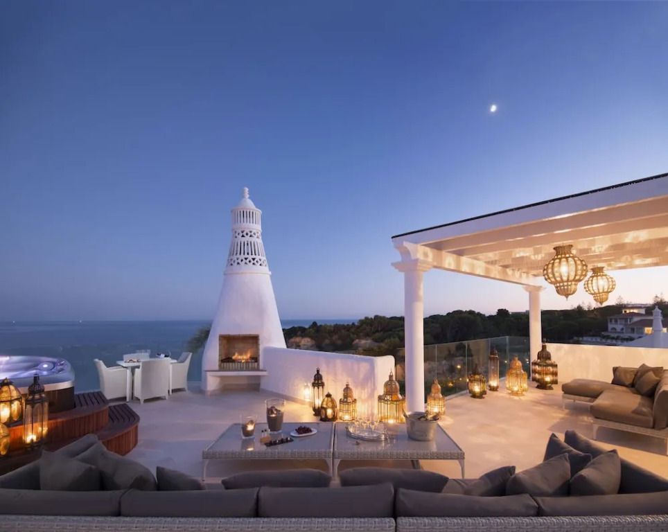 Elegante Terrasse mit Meerblick und stilvoller Beleuchtung bei Dämmerung