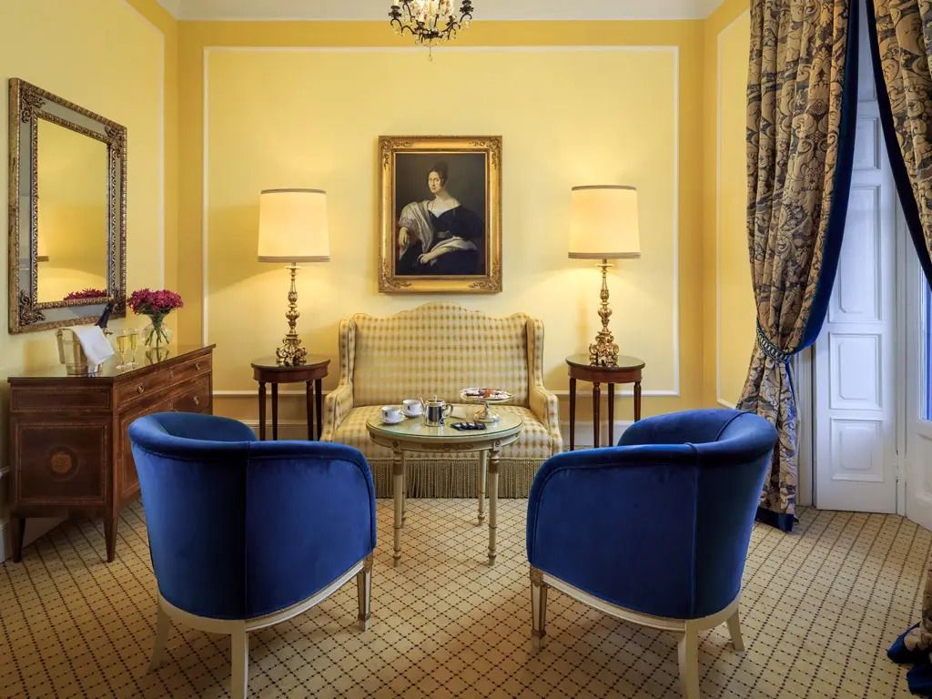 Luxuriöser Wohnbereich mit blauen Sesseln und Gemälde an der Wand.