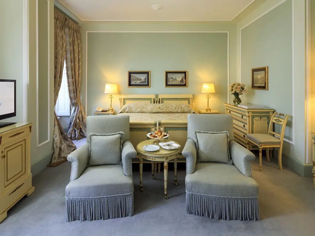 Deluxe Zimmer mit Doppelbett, zwei Lehnstühlen und gediegenem Ambiente