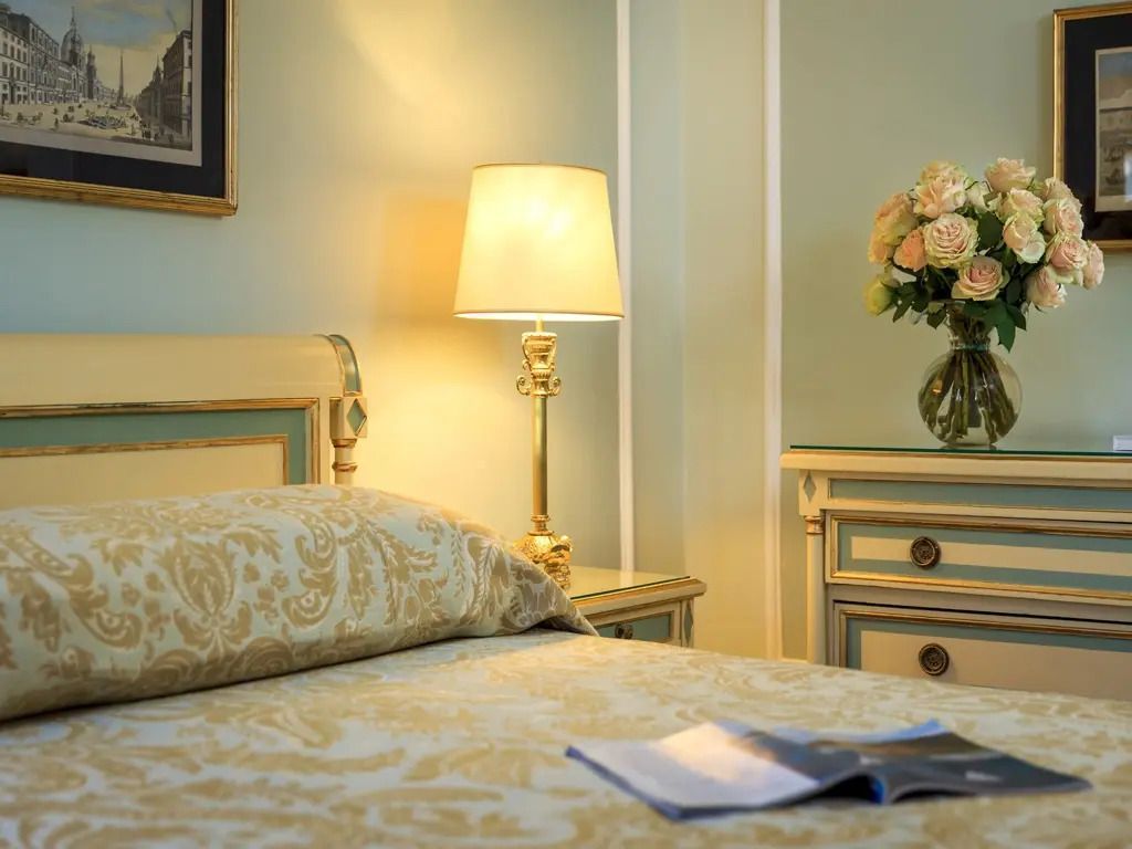 Nachttischlampe und Blumen auf einem Tisch im Deluxe Zimmer