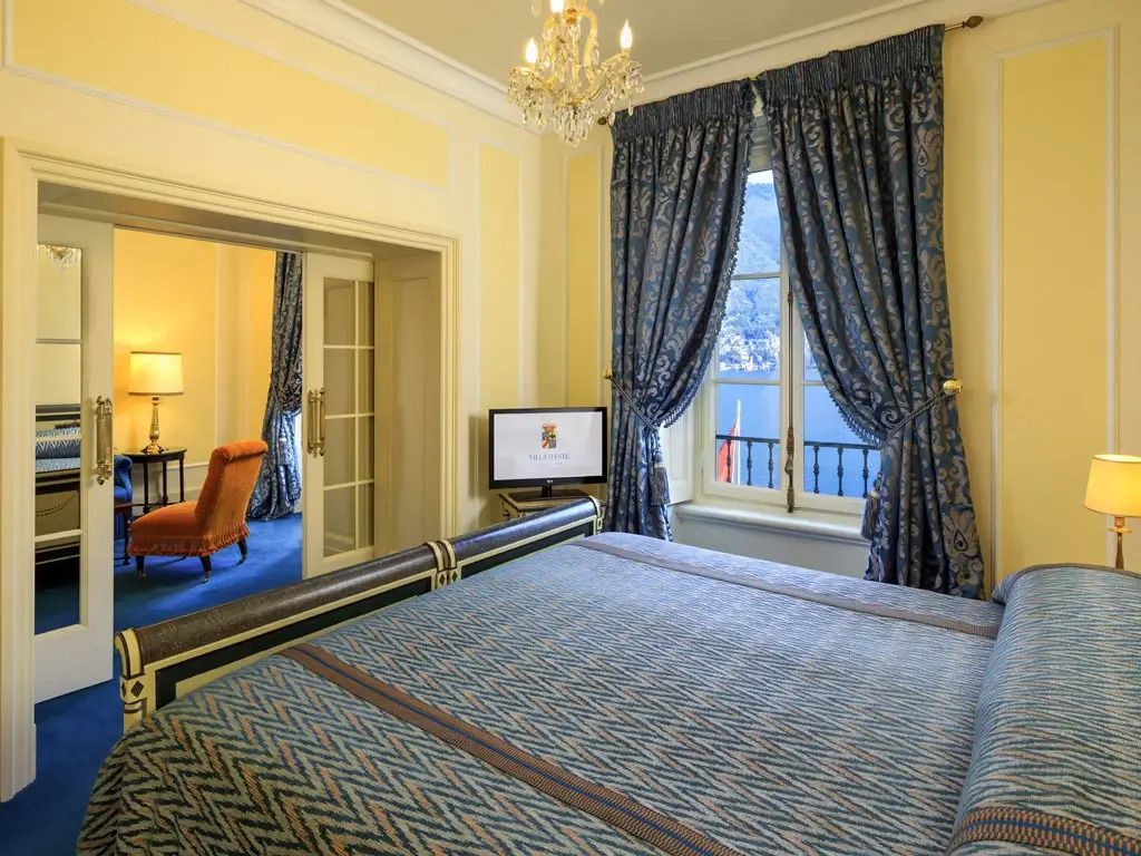 Elegantes Schlafzimmer mit Doppelbett, Seeblick und stilvollen Vorhängen