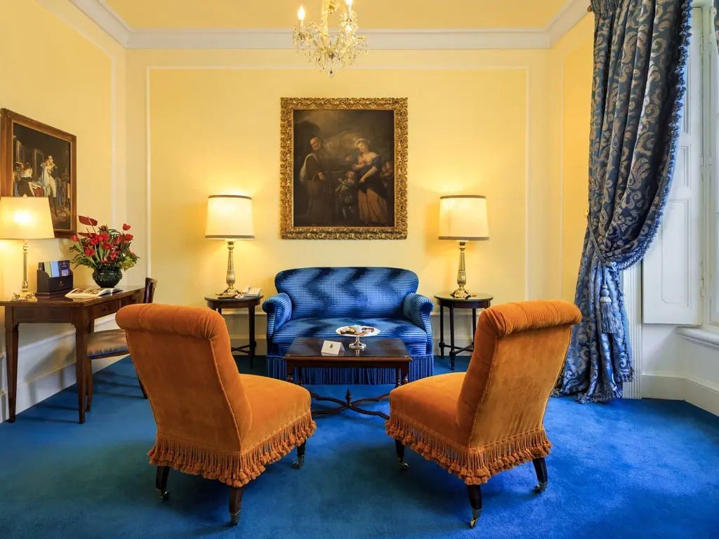 Luxuriöser Wohnbereich mit blauer Couch und goldgerahmtem Gemälde