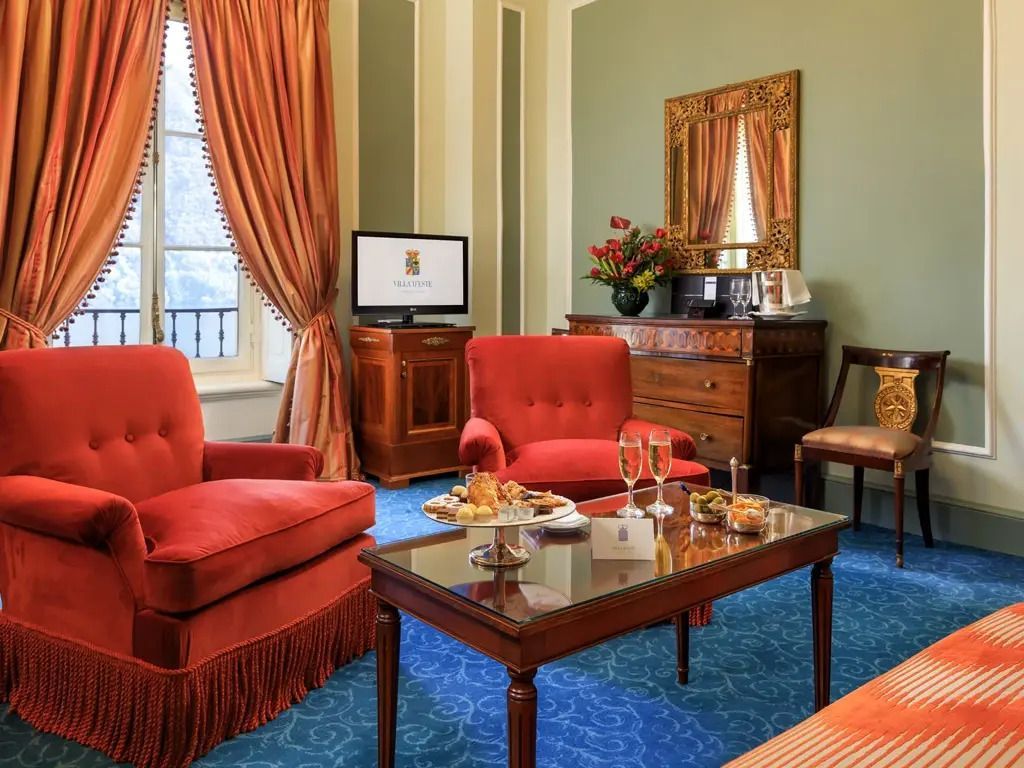 Gemütliche Sitzecke mit Sesseln und Tisch in eleganter Suite mit Seeblick