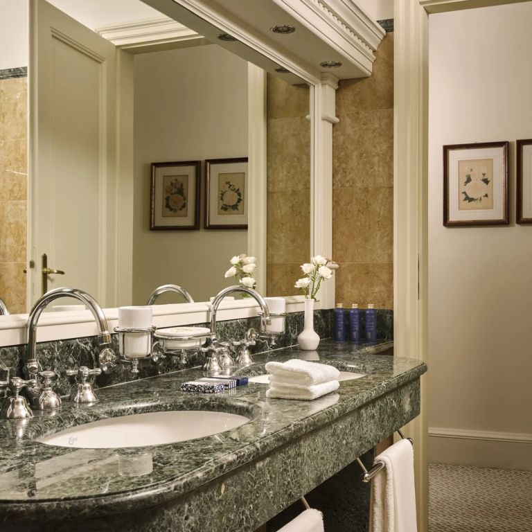 Badezimmer mit Marmor-Waschbecken und eleganten Armaturen in einer Suite