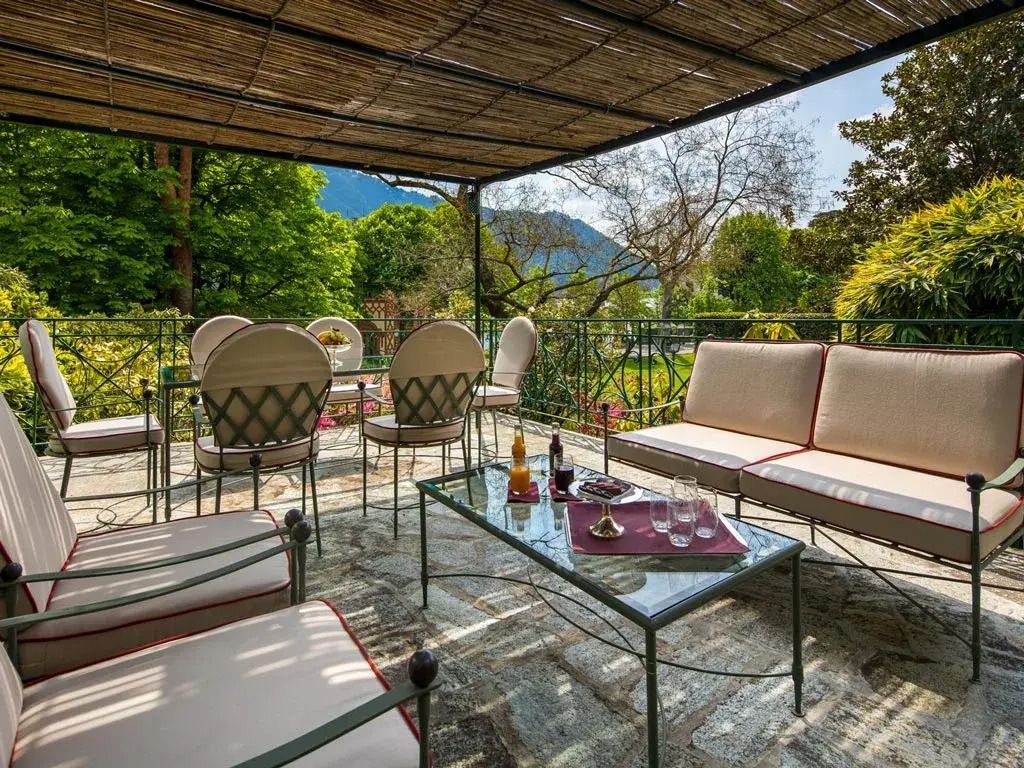 Terrasse mit Sitzgelegenheiten und Blick auf grüne Landschaft in der Villa d'Este