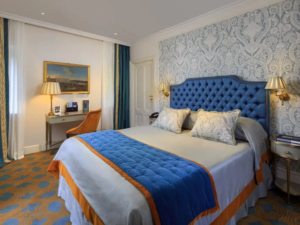 Luxuriöses Schlafzimmer mit blauem Kopfteil und elegantem Design