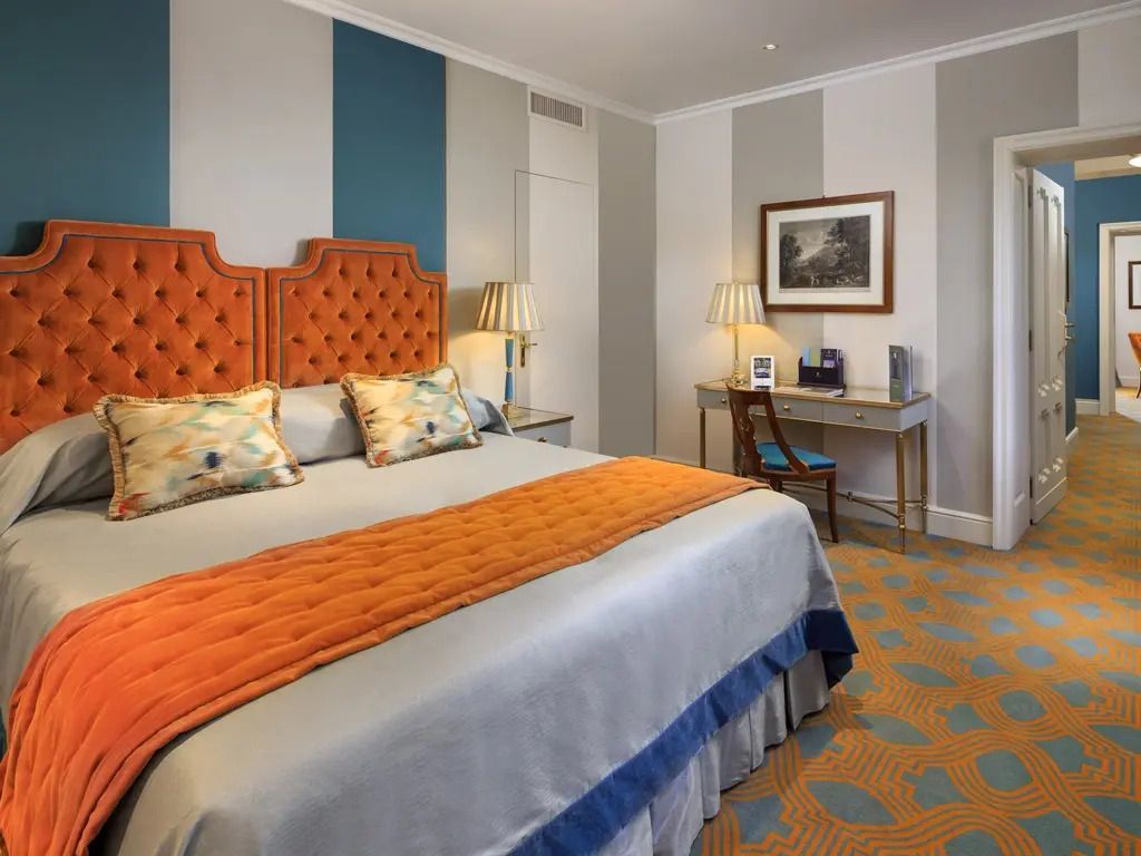 Geschmackvoll eingerichtetes Schlafzimmer mit orangen Details und stilvollem Ambiente