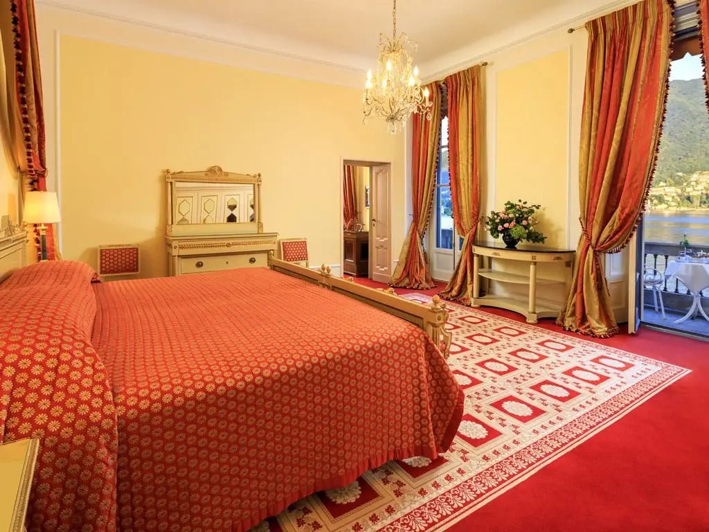 Elegantes Schlafzimmer mit roten Vorhängen und luxuriösem Doppelbett in der Präsidenten Suite