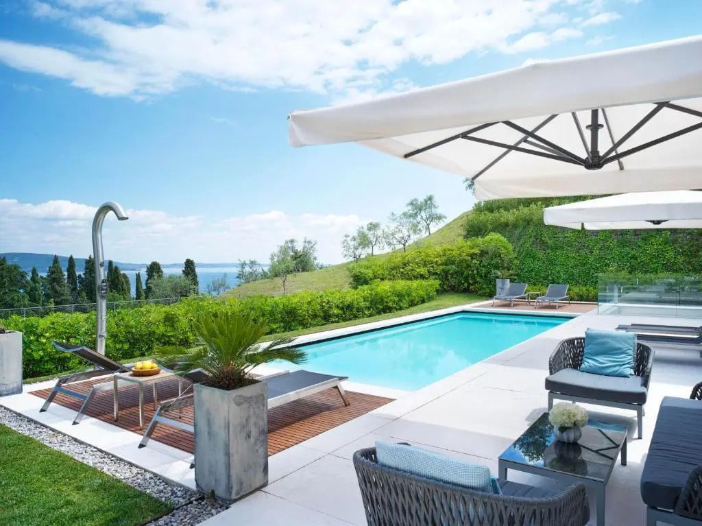Luxuriöser Außenpool mit Liegestühlen und Sonnenschirmen im Hotel Eden Reserve mit Seeblick