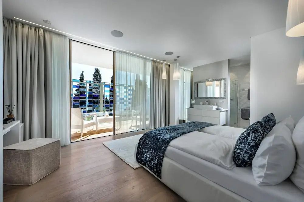 Elegantes Deluxe Zimmer mit Doppelbett und Terrasse mit Blick auf die Natur