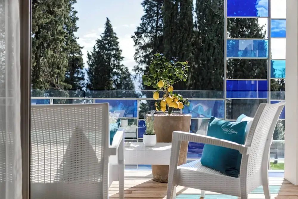 Terrasse mit Sitzmöbeln und Zitronenbaum mit Blick auf Bäume