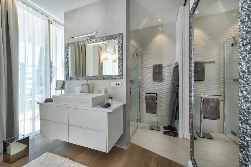 Moderne Badezimmeransicht mit großem Spiegel und ebenerdiger Dusche