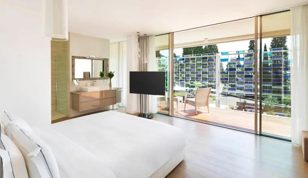 Helles Schlafzimmer mit großem Fenster und Terrasse zum Garten