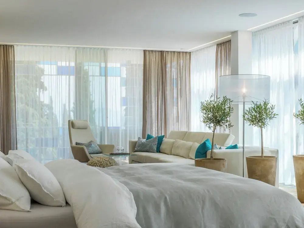 Helles Schlafzimmer einer Premium Suite mit moderner Einrichtung und Sitzbereich