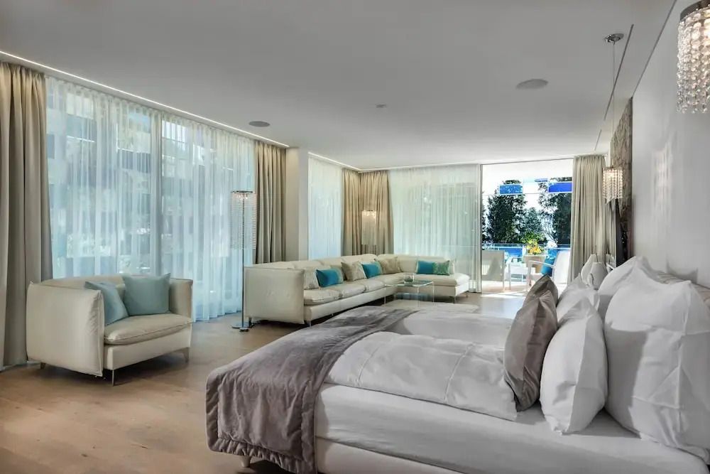 Geräumige Prestige Suite mit hellen Sofas und Blick auf den Balkon