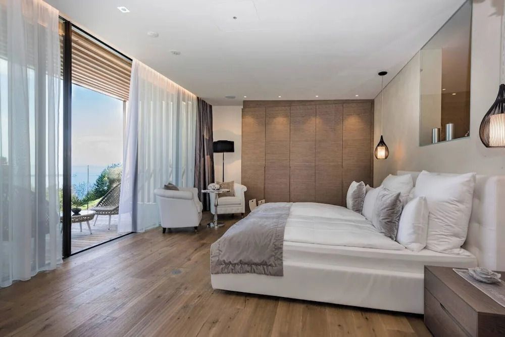 Helles Hotelzimmer mit großem Bett und Blick auf die Natur
