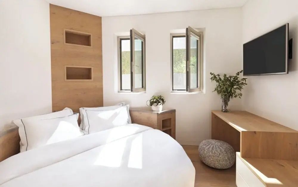 Helles Schlafzimmer mit großen Fenstern und minimalistischer Einrichtung