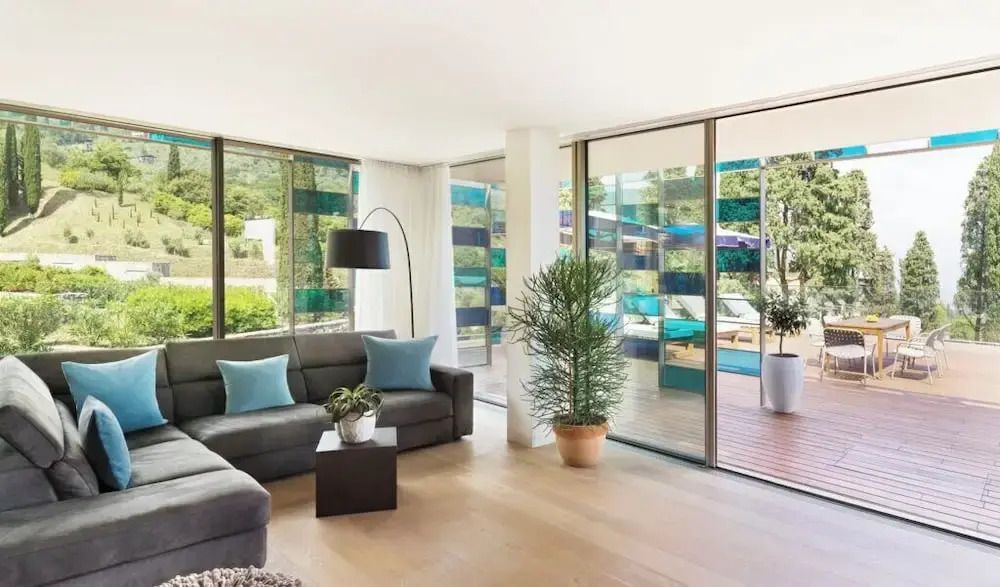 Modernes Wohnzimmer mit Sofas und großen Glasfenstern zur Terrasse
