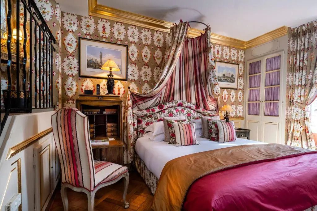 Stilvolles Doppelzimmer mit Blumenmuster und klassischem Mobiliar.