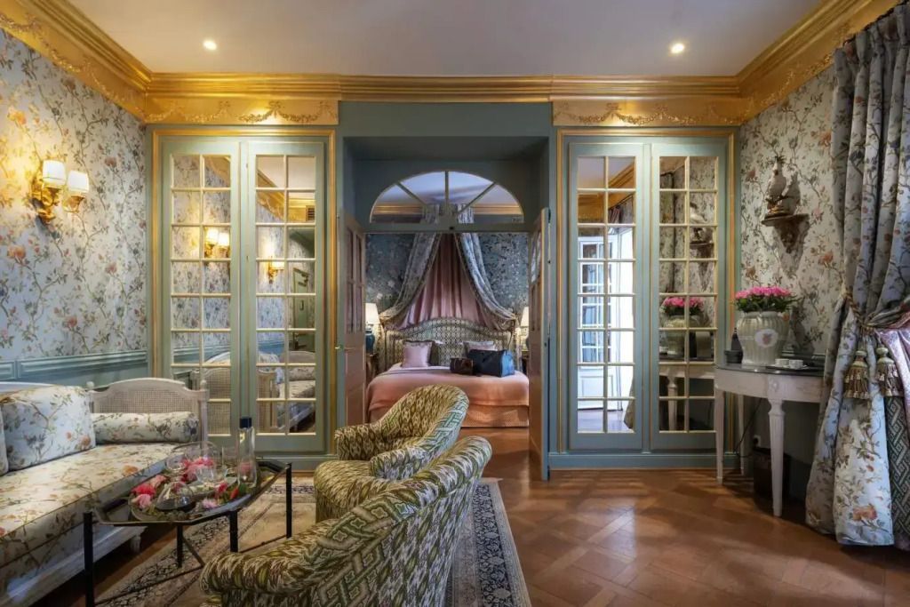 Elegant eingerichtete Suite mit gemütlichem Sitzbereich und großem Bett im Hintergrund