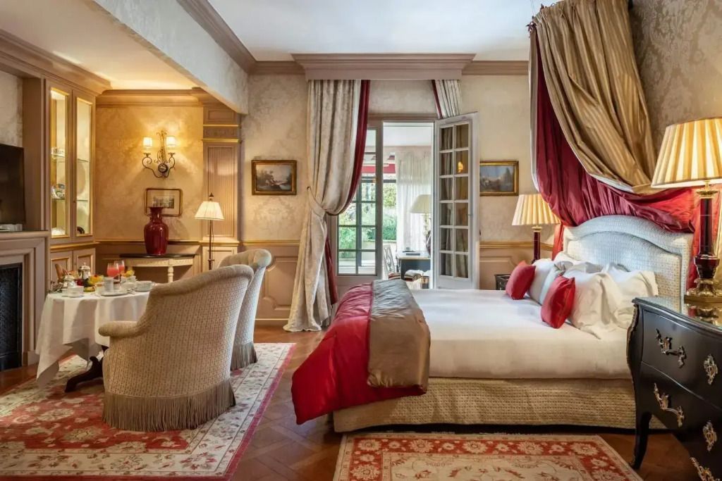 Große Suite mit luxuriösem Baldachinbett und geschmackvoller Dekoration in warmen Farbtönen