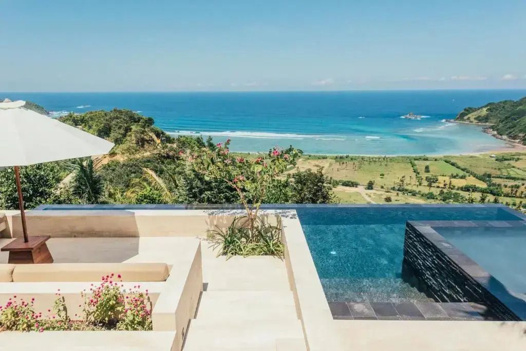 Infinity-Pool mit Blick auf den Ozean und grüne Landschaft