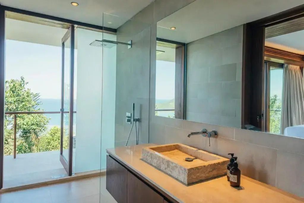 Modernes Badezimmer mit großer Glasdusche und Natursteinwaschbecken