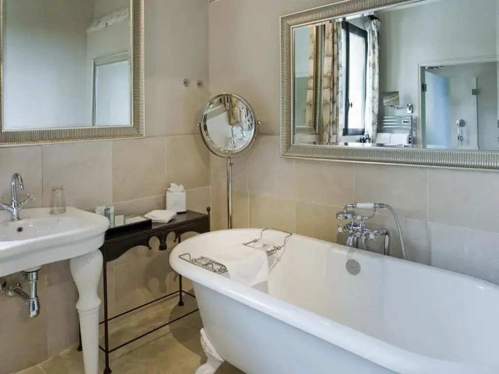 Einladendes Badezimmer mit weißer freistehender Badewanne und großen Spiegeln