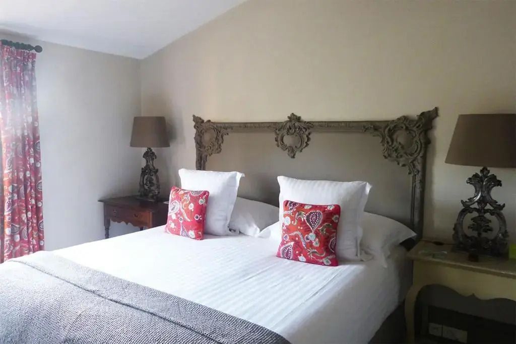 Doppelzimmer mit antikem Kopfteil und farbenfrohen Kissen im Hôtel Villa Marie Saint-Tropez