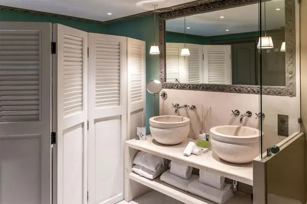 Badezimmer mit Doppelwaschbecken und elegantem Spiegel