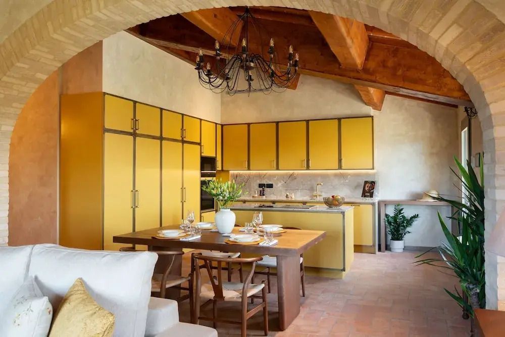 Deluxe Küche mit gelben Schränken und Holzdecke im Villa Petriolo Hotel