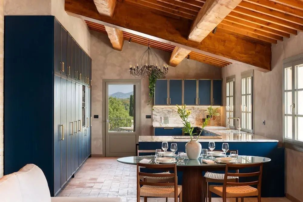 Elegante Küche mit blauen Schränken und Blick in die Landschaft im Villa Petriolo Hotel