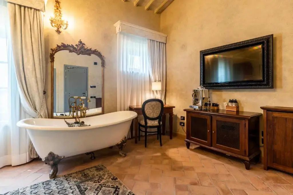 Elegantes Badezimmer mit freistehender Badewanne und antikem Spiegel