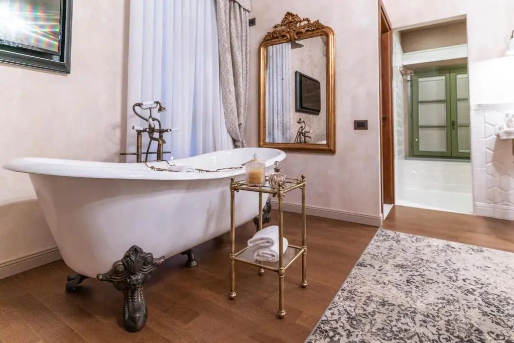 Stilvolles Badezimmer mit freistehender Badewanne und opulentem Spiegel