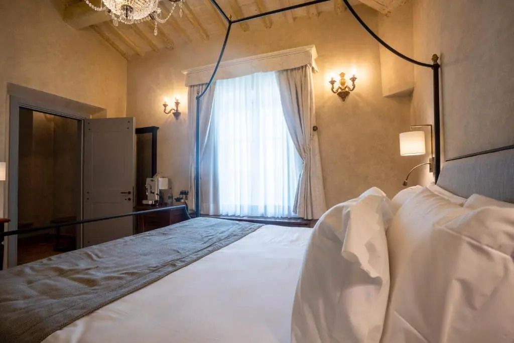 Elegantes Schlafzimmer mit Kronleuchter und stilvollem Vorhang
