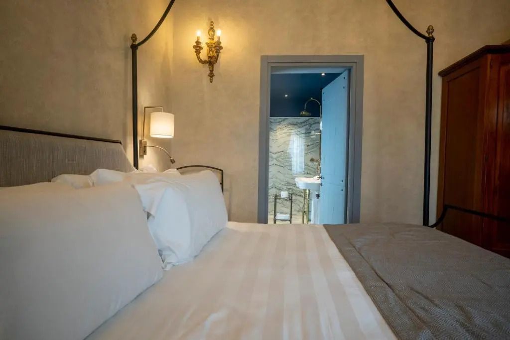 Blick aus dem Bett auf elegantes Badezimmer mit Marmordesign