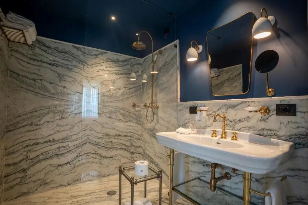 Luxuriöses Badezimmer mit goldenen Armaturen und marmornem Finish