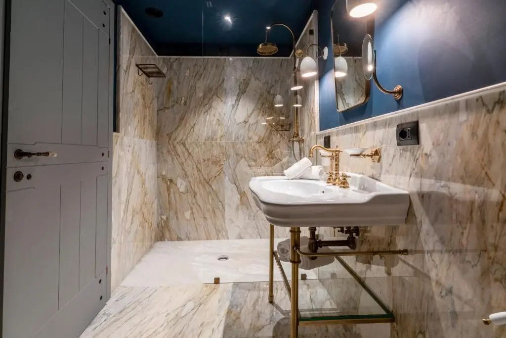 Modernes Badezimmer mit Marmorwänden und edler Ausstattung