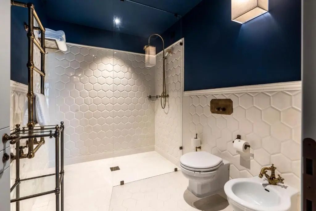 Modernes Badezimmer mit Dusche, weißen Fliesen und blauer Akzentwand