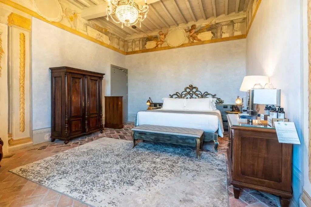 Elegante Superior Suite mit rustikalen Möbeln und dekorativer Decke im Hotel Villa Petriolo