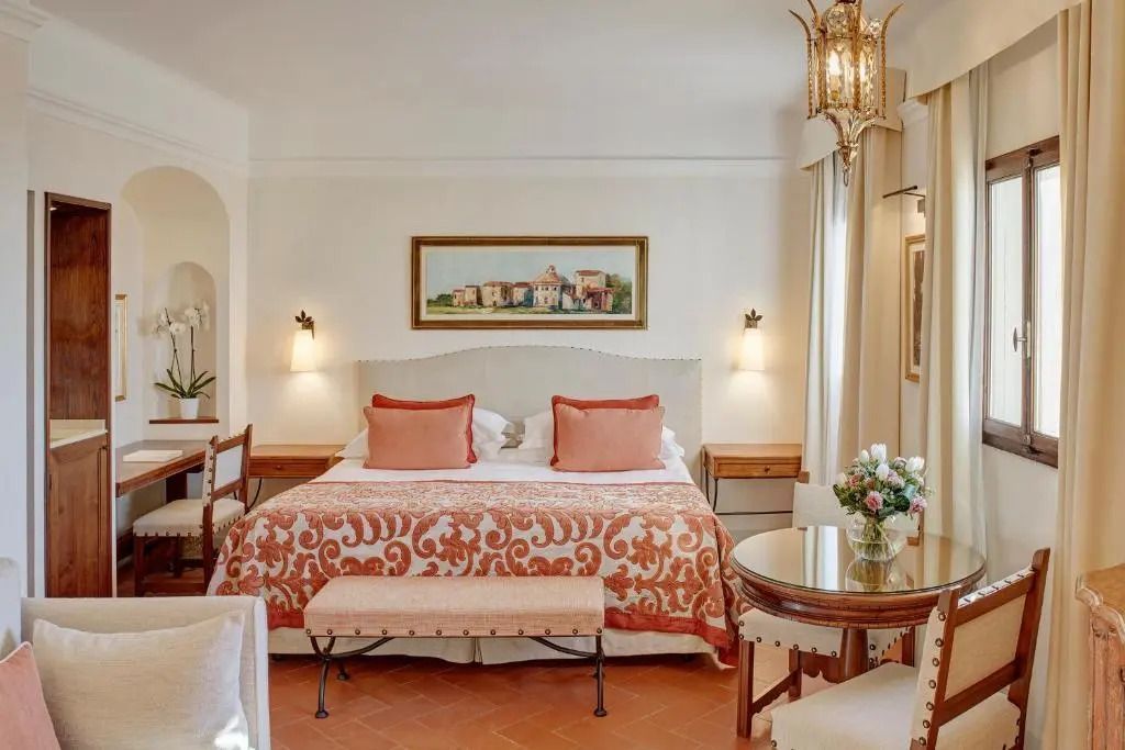 Elegantes Deluxe Doppelzimmer mit Doppelbett und Blumenarrangement