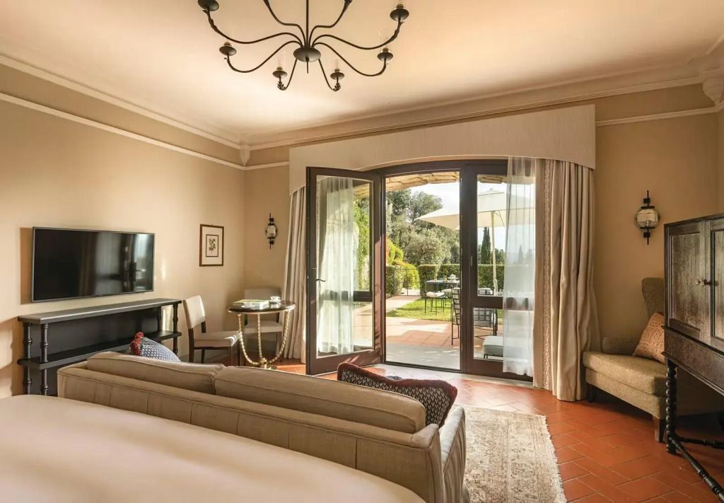 Junior-Suite mit großer Glastür und Blick auf die Terrasse und den Garten