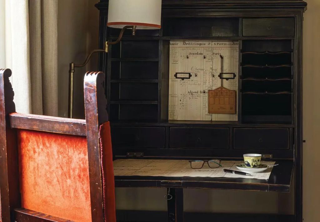 Schreibtisch mit antikem Holzstuhl und Lampe in der Suite