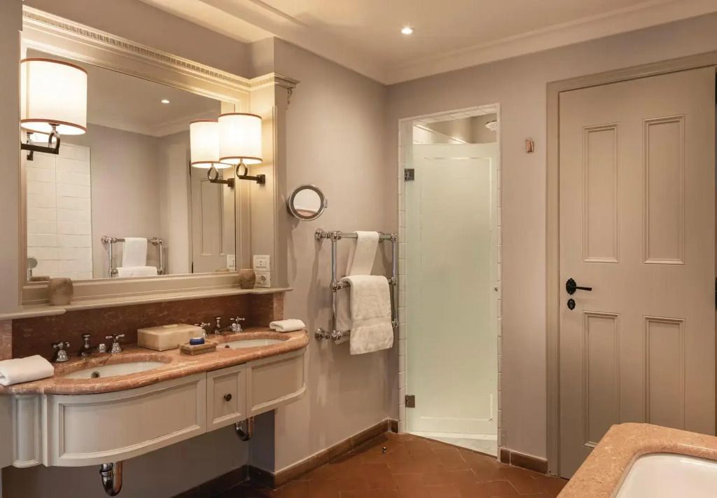 Modernes Badezimmer mit Doppelwaschbecken und Dusche in der Suite